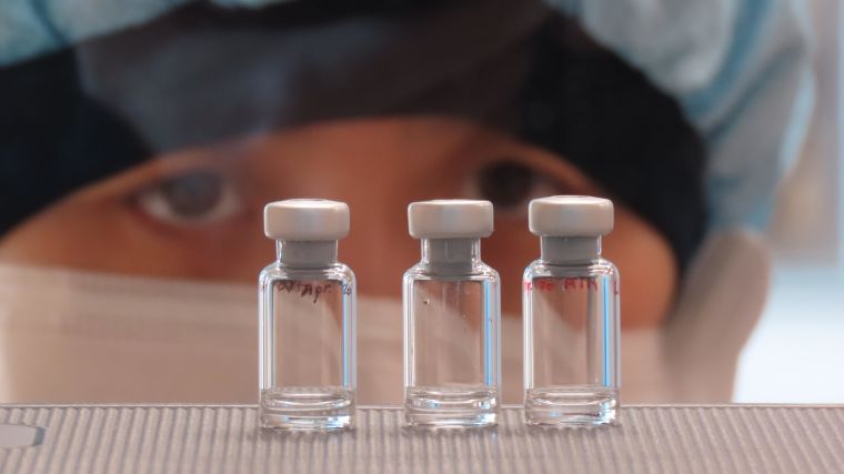 Researcher examining vials.
